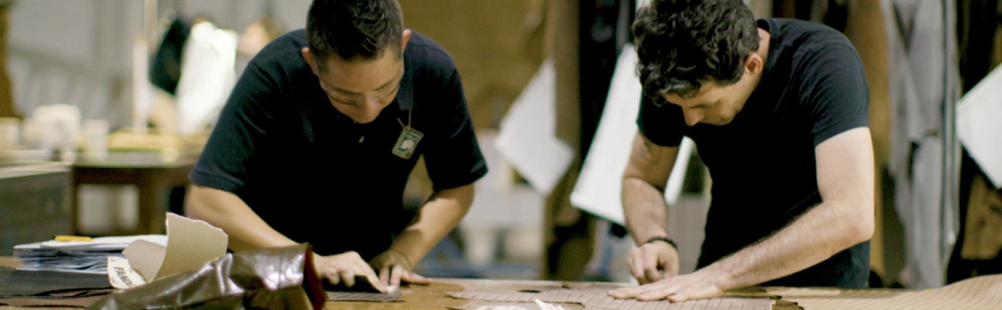 two men cutting leather